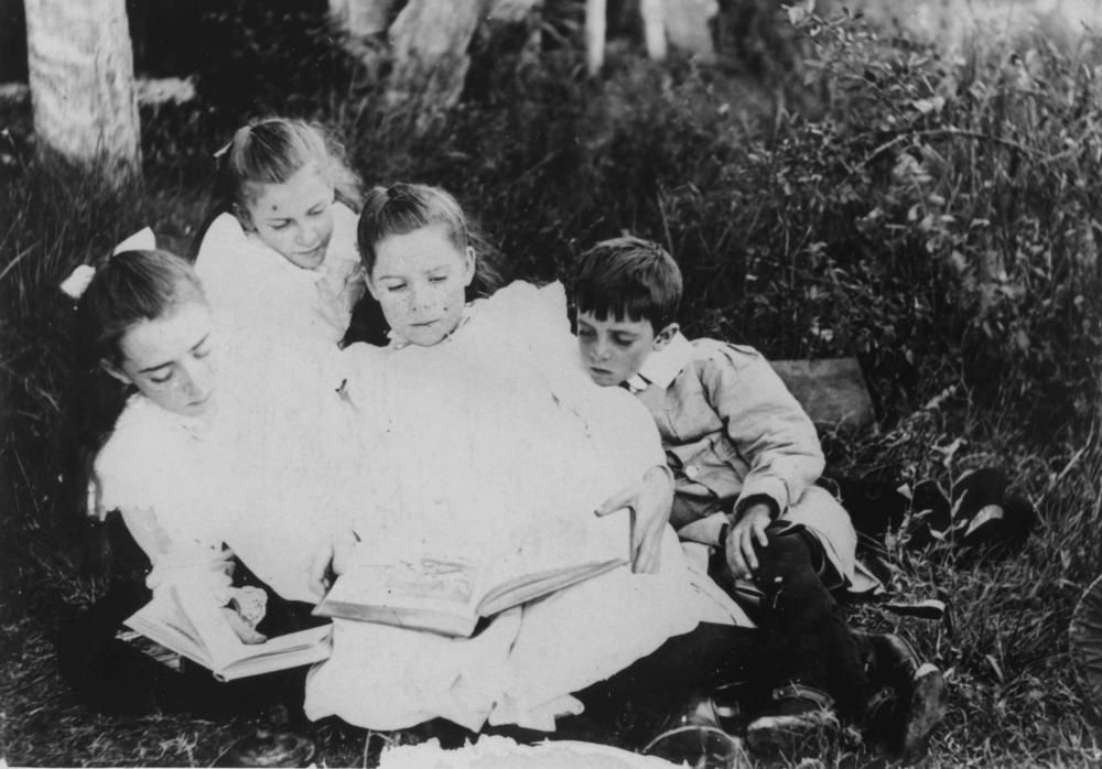 Children reading together on the grass, Queensland, about 1905